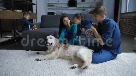 与孩子和狗一起休息的幸福家庭视频的预览图