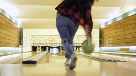 年轻女子投掷保龄球时摔倒视频的预览图