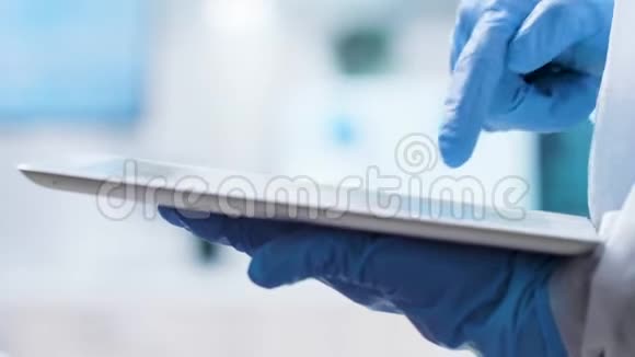 科学家戴手套在平板电脑屏幕上打字的特写镜头视频的预览图