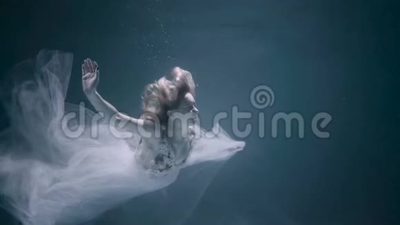穿着白色连衣裙的年轻女人在水下游泳视频的预览图