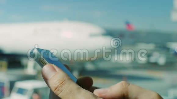 商人在机场使用智能手机在机场背景下拿着电话的人的手视频的预览图