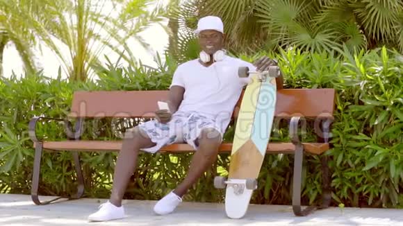帅气运动的非洲男人带着滑板视频的预览图