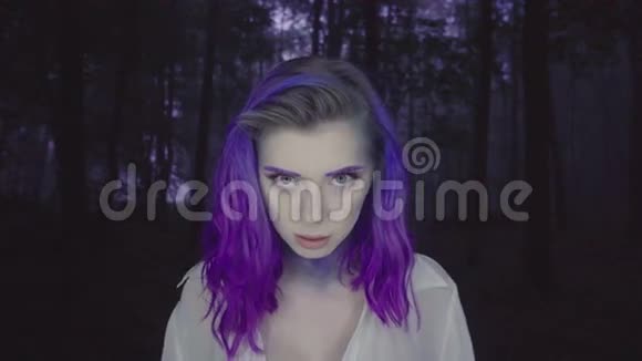 在黑暗的森林中紫色的头发和化妆的美丽女人的特写童话场景视频的预览图