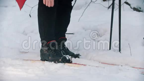 一个女人把靴子锁在滑雪板上视频的预览图
