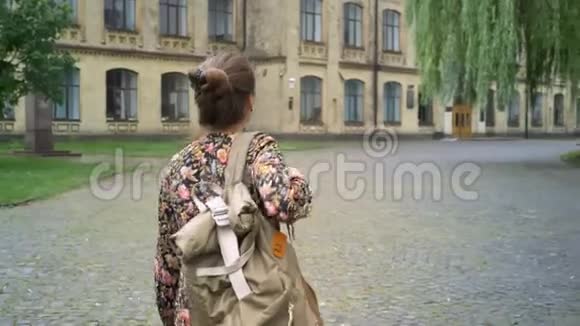 年轻开朗的女大学生背着背包上大学走在大学附近的街道上美丽而又美丽视频的预览图