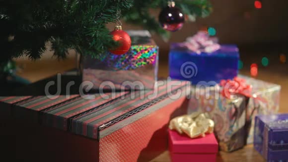 圣诞手把圣诞礼物放在圣诞树下视频的预览图