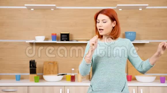手里拿着木勺的女人在厨房唱歌视频的预览图