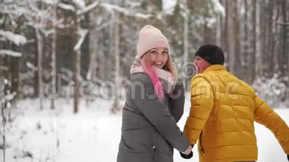 一对年轻漂亮的夫妇在公园里玩得很开心跑着牵着手情人节爱情故事视频的预览图