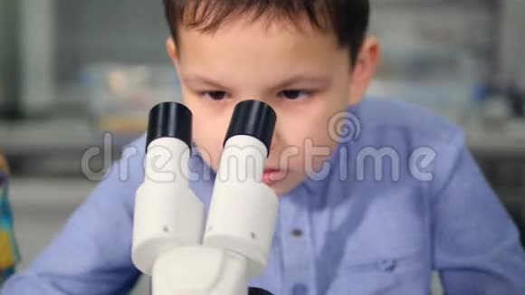 学校的孩子在化学教室里看显微镜做科学实验视频的预览图