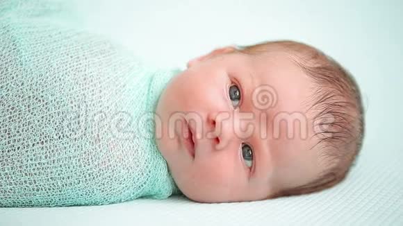 蓝眼新生婴儿躺着惊奇地环顾四周视频的预览图