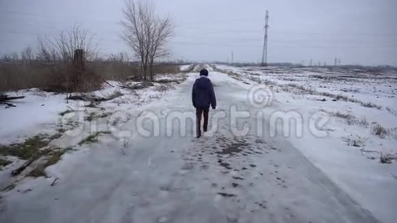 男孩走在结冰的路上视频的预览图