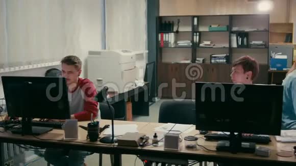 年轻雇员在办公室的电脑上工作视频的预览图