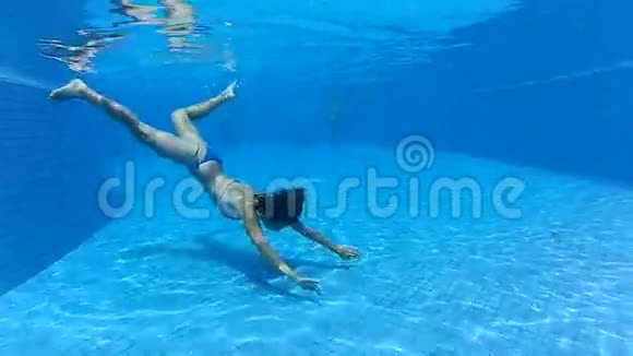 小女孩在蓝色的游泳池里水下游泳视频的预览图