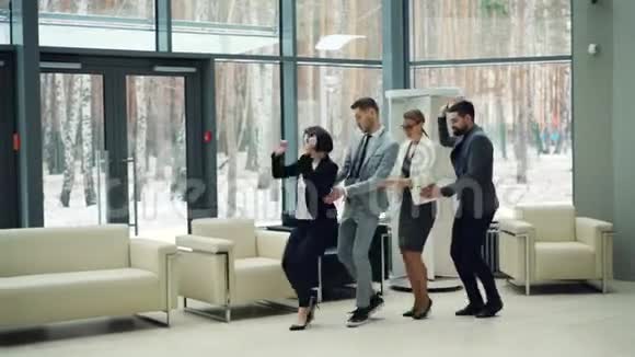 漂亮的男人和女人商务人士在大厅里跳舞一起欢笑在公司聚会上玩得开心视频的预览图
