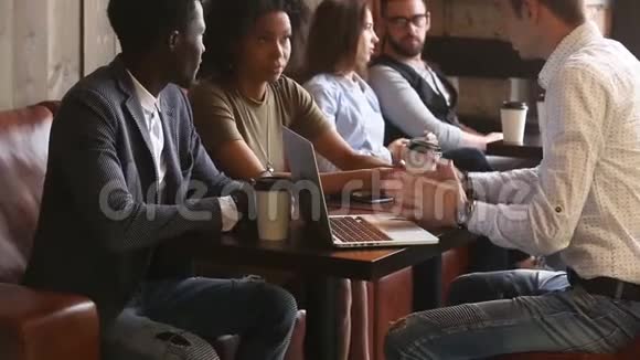 一对非洲夫妇在咖啡馆里做着握手的白种人律师视频的预览图