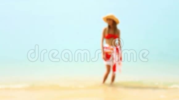 在阳光下的热带海滩散步的女人视频的预览图