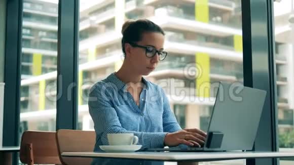 咖啡馆和一个在电脑里工作的女人视频的预览图