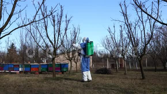 园丁穿着防护的整体撒果树与长喷雾器在果园里视频的预览图