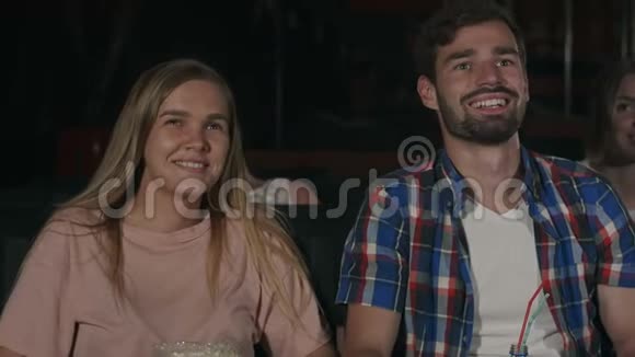 在电影院的一部电影中美丽的一对夫妇在和她的男人笑着说悄悄话视频的预览图