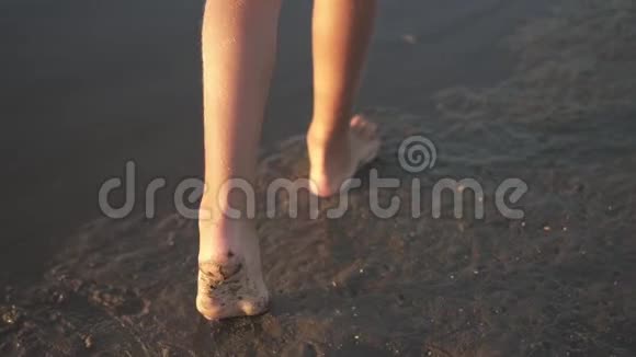 少女的脚踩在潮湿的沙滩上视频的预览图