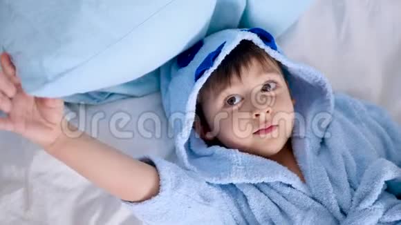 穿着蓝色长袍的孩子躺在床上视频的预览图