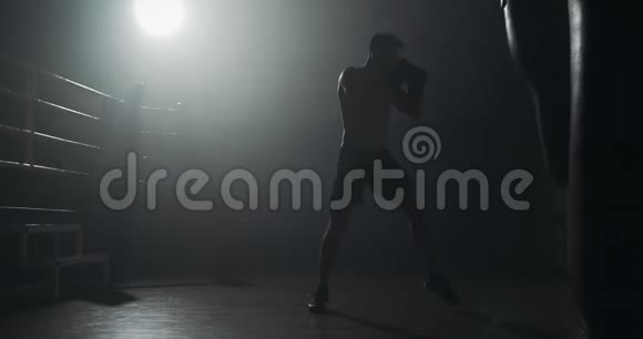 剪影拳击手在黑暗的健身房打拳体力锻炼男拳击手在黑暗中锻炼跆拳道剪影视频的预览图
