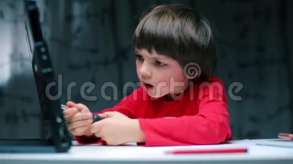 这个男孩正在修理一台笔记本电脑视频的预览图
