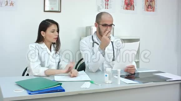 医生向女学员展示如何在做笔记的时候读心电图视频的预览图