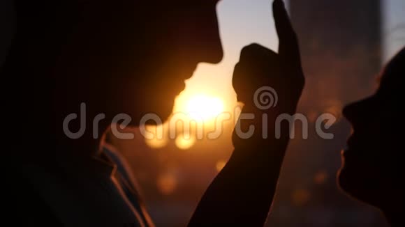 恋爱中的年轻夫妇看着对方眼睛对着夕阳用镜头的效果他的手指朝下视频的预览图