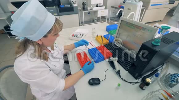 一名实验室工作人员移动血液样本在现代实验室进行医学测试视频的预览图