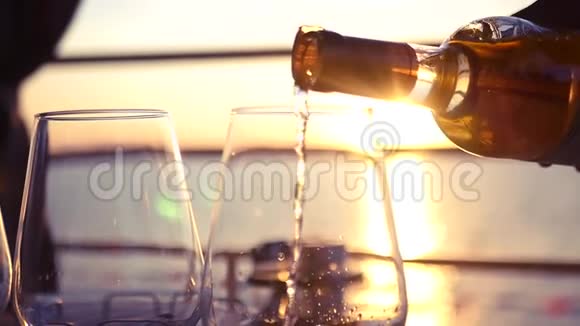 日落时在海边倒上可口的白葡萄酒高清1920x1080慢动作视频的预览图