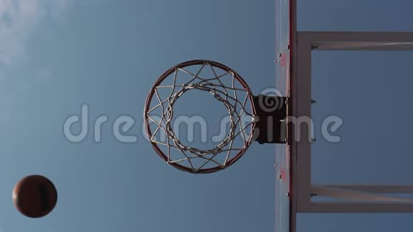 在蓝天背景下缓慢运动的篮篮球得分的低角度视图健康生活方式和运动视频的预览图