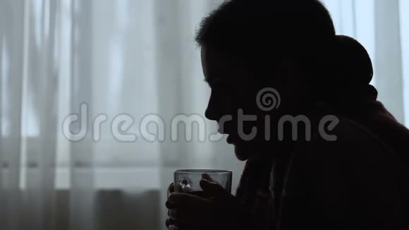 寒战妇女发烧喝热茶流感治疗剪影视频的预览图