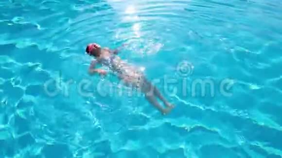 小女孩漂浮在游泳池里视频的预览图