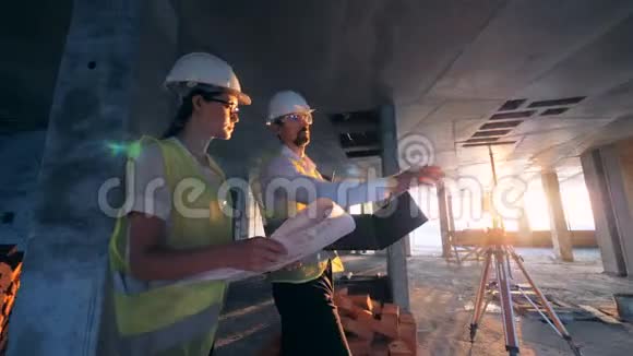 建筑中有一个男女建筑工人建筑工人工程师沿着它走视频的预览图