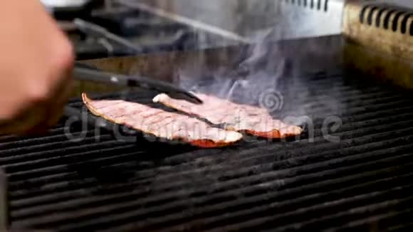 厨师把两块熏肉放在烤架上视频的预览图