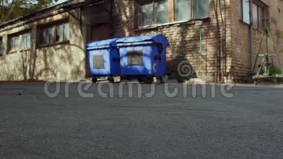 无家可归的人把购物车推到垃圾桶的后视镜视频的预览图