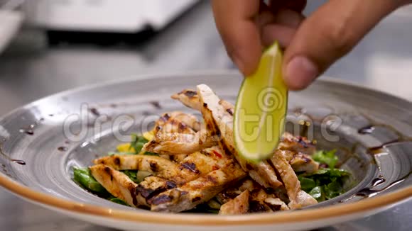煮熟的手把一块石灰放在鳄梨沙拉和烤肉上视频的预览图