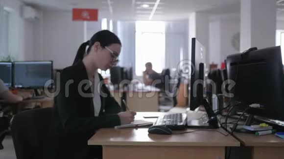 勤奋的办公室工作沮丧的戴眼镜的女商人用电脑做笔记视频的预览图