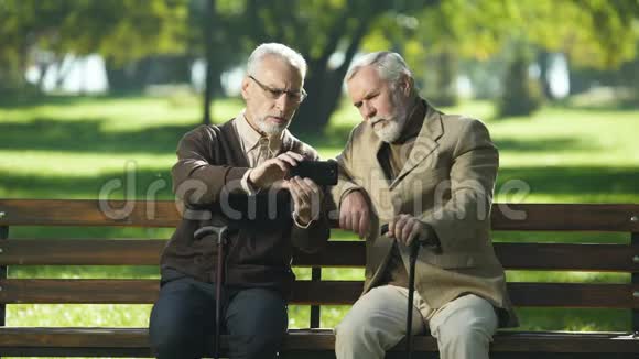 两个老朋友自拍在公园玩新的现代技术视频的预览图
