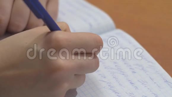 女性手在笔记本上用钢笔写作把女人的手放在木制桌面上的螺旋记事本上写字视频的预览图