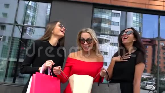 三个有魅力的女人在讨论她们的购物日三个女孩在商场购物后寻找零售金发美女视频的预览图
