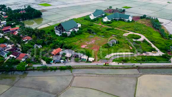 空中观景乡间的房屋和田野被绿树和稻田包围着视频的预览图