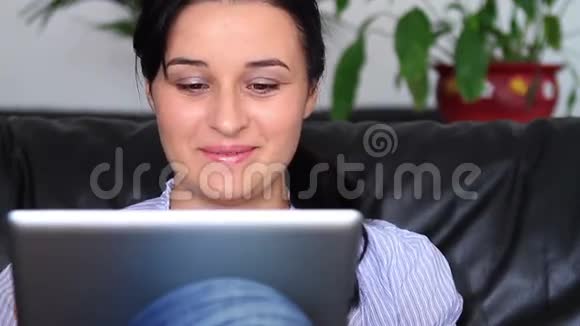 年轻女性在家使用平板电脑视频的预览图