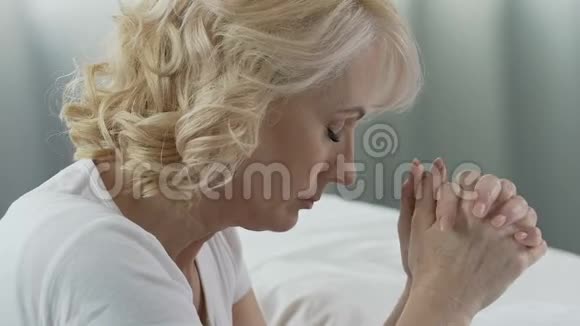 老年女性在床上虔诚祈祷寻求帮助严重疾病视频的预览图