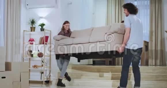 有魅力的男人和他的女朋友搬到了一个新的公寓他们在沙发中间做了一些改变视频的预览图