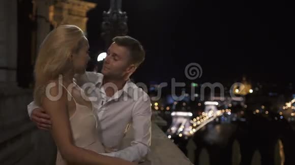 在古城背景下一对情侣在阳台上接吻视频的预览图