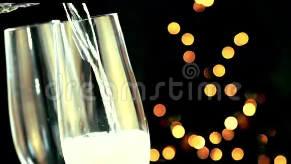 将香槟倒入带有金色气泡的长笛金色的抽象闪烁模糊的圣诞树灯光视频的预览图