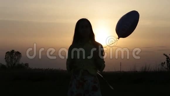 日落时分有心形气球的漂亮女人视频的预览图