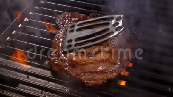 厨师把牛排压在烤架上视频的预览图
